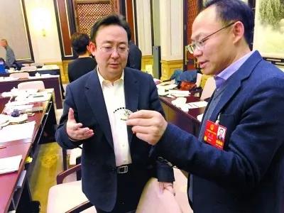 昨天,北京團(tuán)小組會(huì)休息的間隙,程京代表(右)向夏林茂代表介紹基因芯片。張宇攝